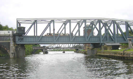 boat on the Bridgewater Canal passes across Barton Swing Aqueduct on the Manchester Ship Canal